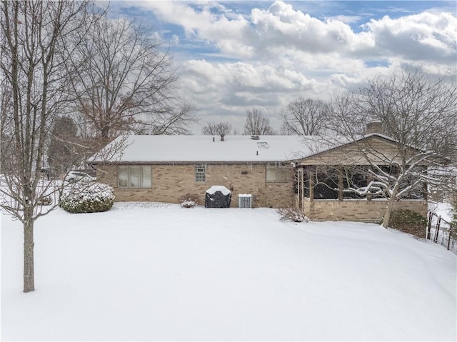 snow covered house with central AC unit