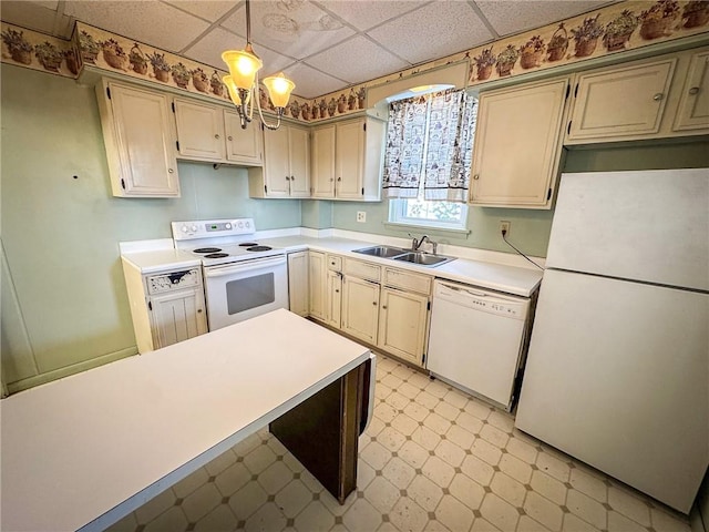 kitchen featuring white appliances, light floors, a sink, light countertops, and a paneled ceiling