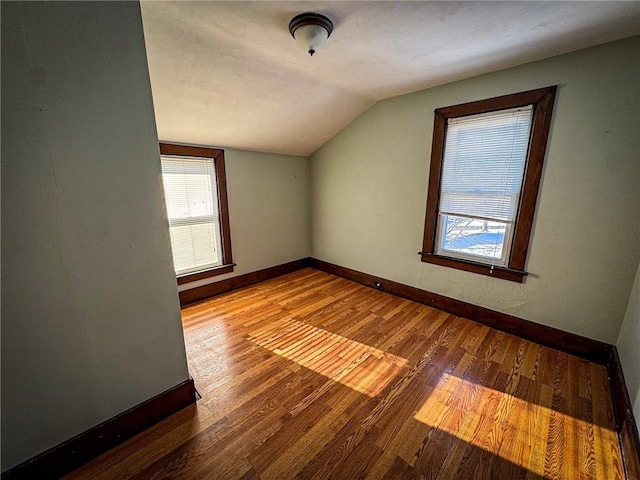 bonus room with baseboards, hardwood / wood-style floors, and vaulted ceiling