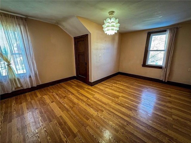 bonus room featuring lofted ceiling, wood finished floors, and baseboards