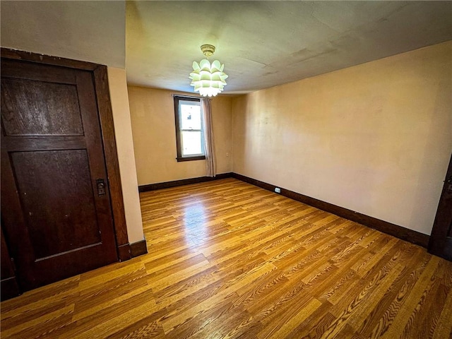 unfurnished bedroom featuring wood finished floors and baseboards