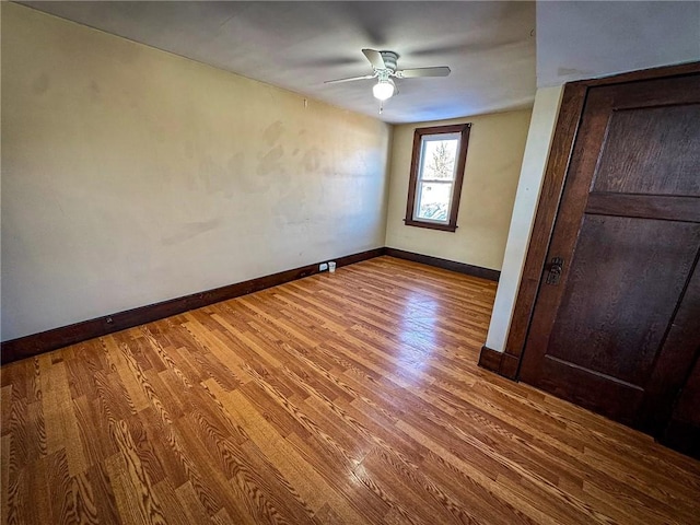 unfurnished bedroom with baseboards, wood finished floors, and a ceiling fan