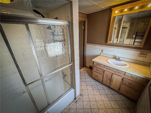 bathroom featuring tile walls, vanity, and walk in shower