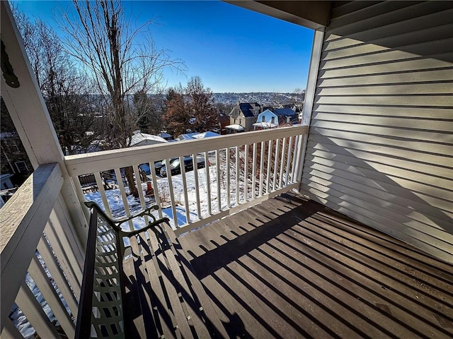 snow covered deck featuring a residential view