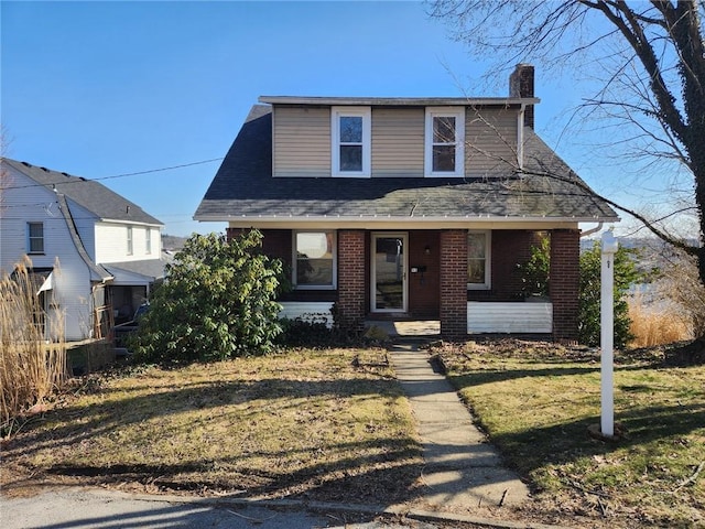 bungalow-style home with brick siding, a front lawn, a chimney, and a shingled roof