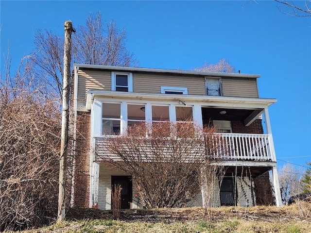 view of front of house featuring brick siding and a sunroom