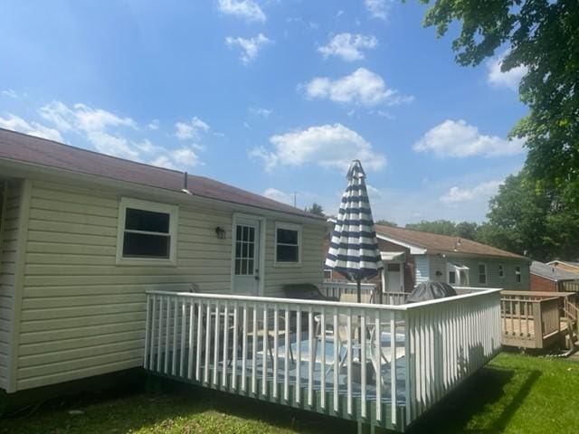 rear view of house with a deck and a yard