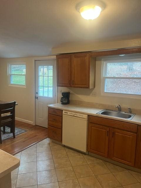 kitchen with dishwasher, sink, and light hardwood / wood-style flooring