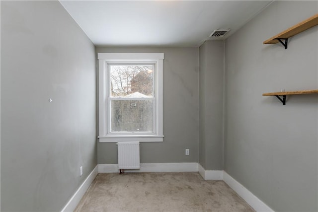 carpeted spare room with radiator