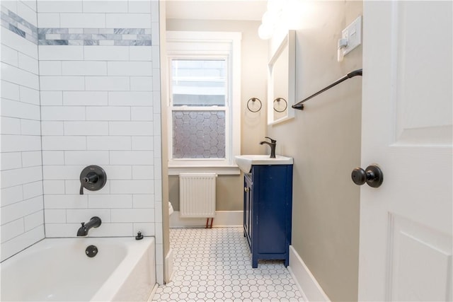 bathroom featuring vanity, tiled shower / bath combo, and radiator