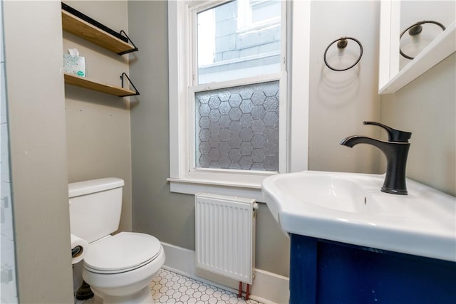 bathroom with vanity, toilet, and radiator