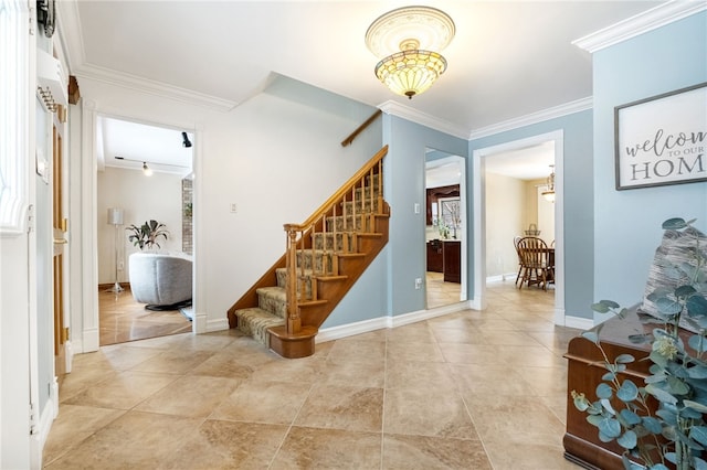 foyer entrance with light tile patterned floors, crown molding, baseboards, and stairs