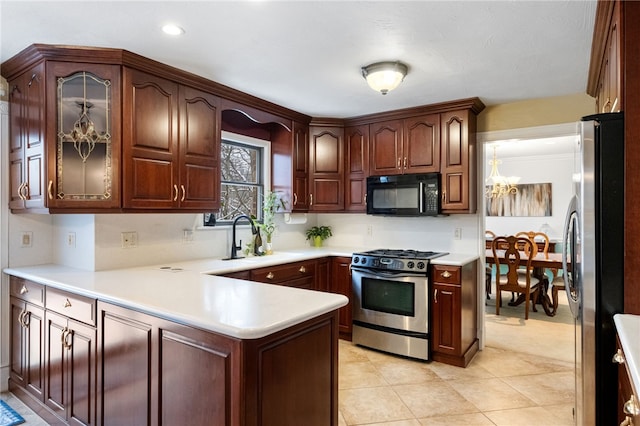 kitchen featuring sink, a notable chandelier, kitchen peninsula, light tile patterned floors, and appliances with stainless steel finishes