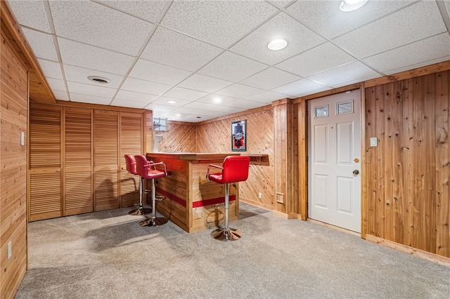 bar featuring carpet and wood walls