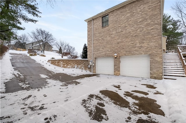 view of snow covered exterior featuring a garage