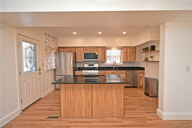 kitchen featuring sink, stainless steel appliances, a healthy amount of sunlight, and a kitchen island