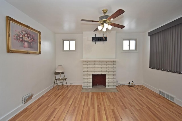 unfurnished living room with plenty of natural light, a fireplace, and light wood-type flooring