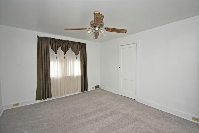 carpeted spare room featuring ceiling fan