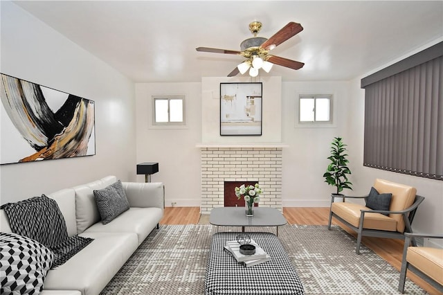 living room featuring a brick fireplace, a wealth of natural light, and light wood-type flooring