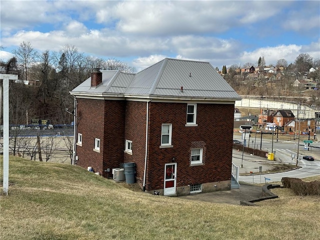 view of home's exterior featuring central AC unit and a yard