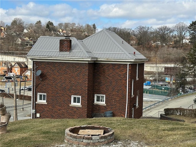 view of side of home featuring a yard and a fire pit