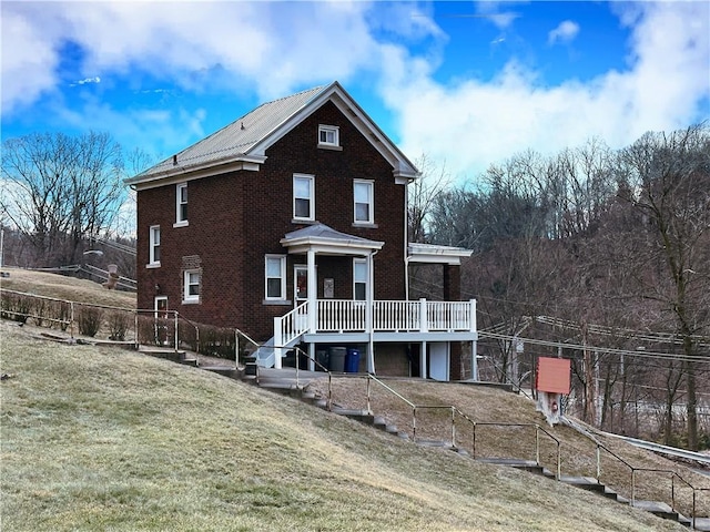 back of house featuring a wooden deck and a yard