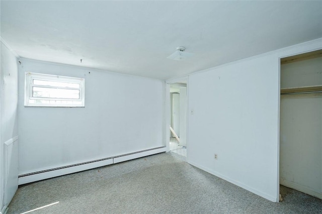 unfurnished bedroom featuring baseboard heating, a closet, and light colored carpet