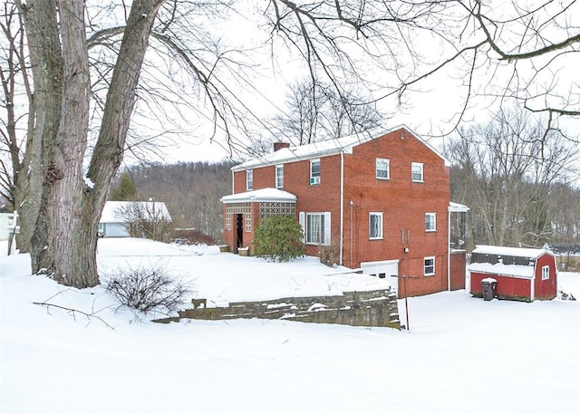 view of snow covered exterior with an outbuilding