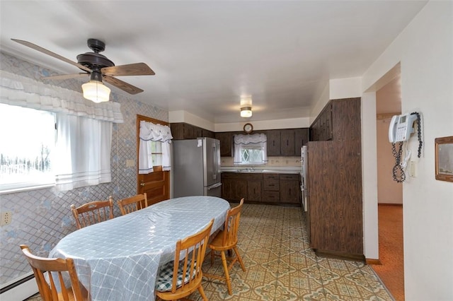 dining space with ceiling fan and a baseboard heating unit