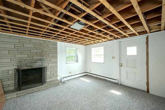 basement with a stone fireplace and a baseboard radiator