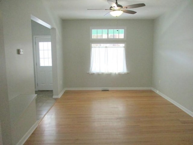 unfurnished room with ceiling fan, light hardwood / wood-style flooring, and a healthy amount of sunlight