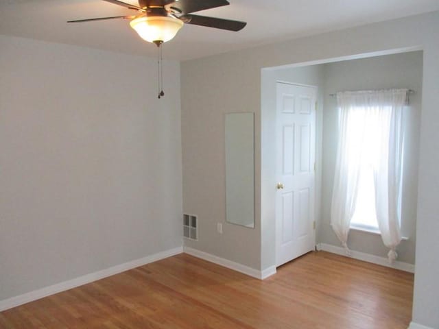 unfurnished room featuring ceiling fan, light wood-type flooring, and plenty of natural light