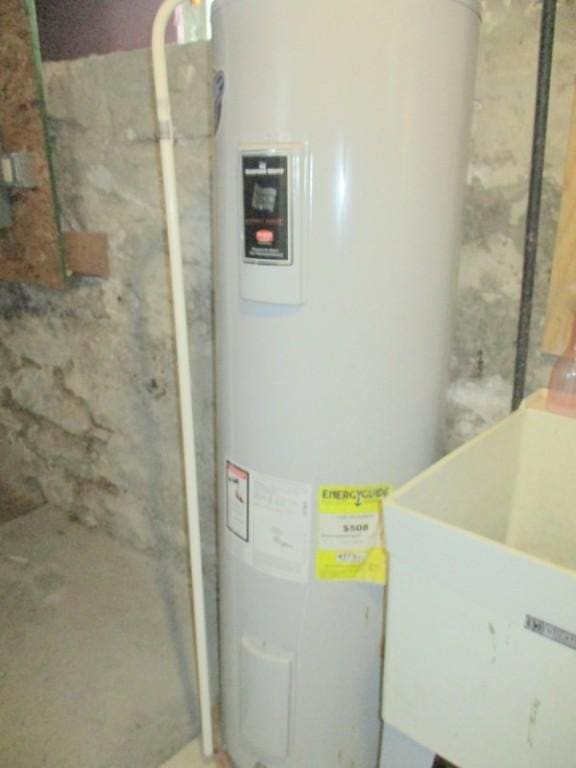 utility room featuring electric water heater and sink