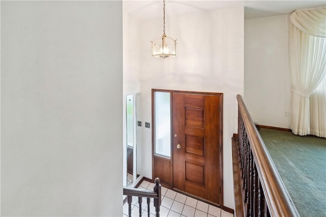 entryway featuring baseboards, an inviting chandelier, and light tile patterned floors