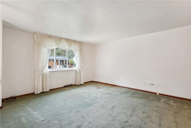 carpeted spare room featuring visible vents and baseboards