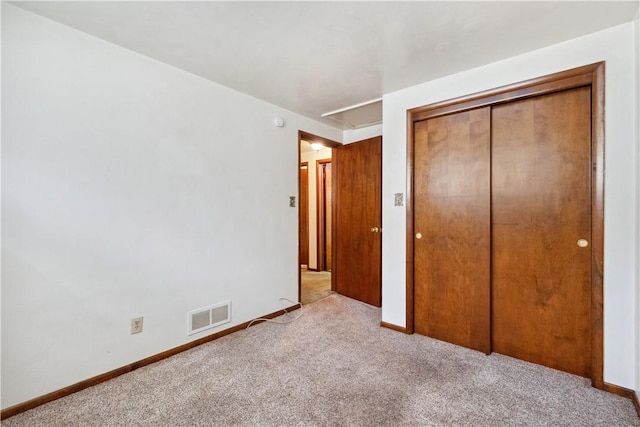unfurnished bedroom featuring baseboards, carpet flooring, visible vents, and a closet