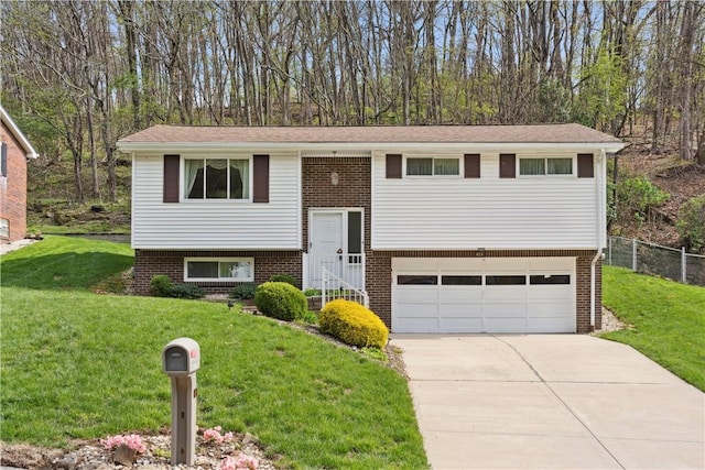 bi-level home featuring fence, an attached garage, a front lawn, and driveway
