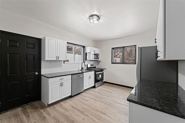 kitchen with white cabinetry, sink, stainless steel appliances, and light hardwood / wood-style flooring