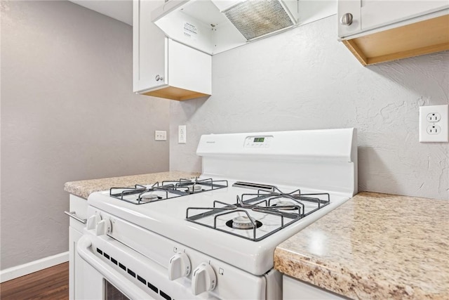 kitchen with dark wood-type flooring, white gas stove, white cabinets, and extractor fan