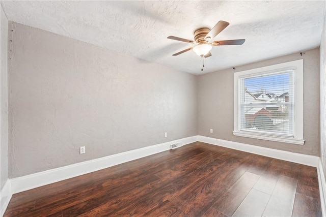 spare room featuring a textured ceiling, ceiling fan, and dark wood-type flooring