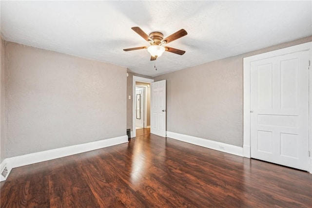 spare room with ceiling fan and dark wood-type flooring