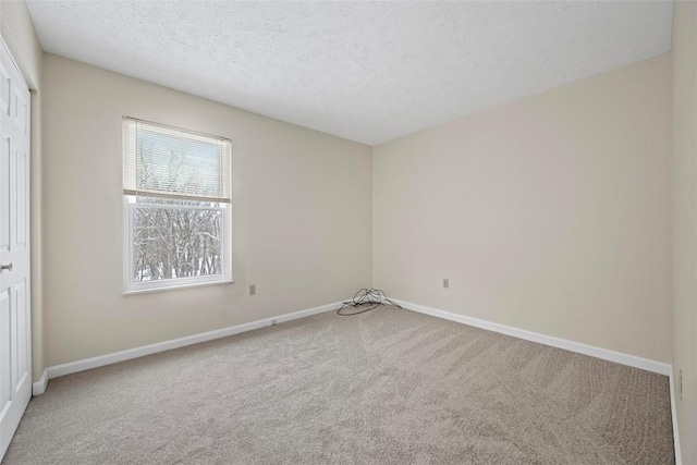 carpeted empty room with a textured ceiling