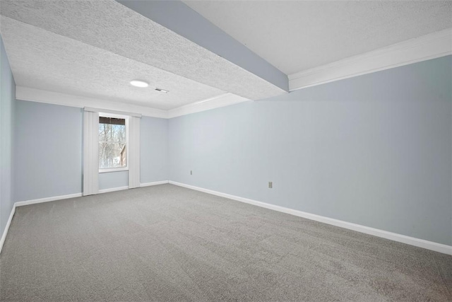 carpeted spare room with a textured ceiling and a tray ceiling