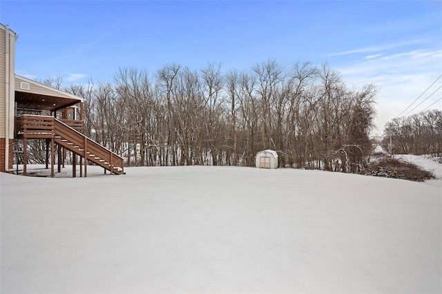 snowy yard featuring a shed