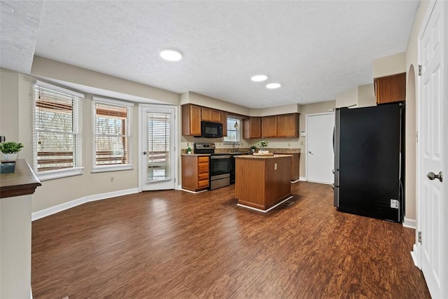 kitchen featuring dark wood-type flooring, refrigerator, electric stove, a textured ceiling, and a kitchen island