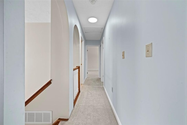 hallway featuring light colored carpet