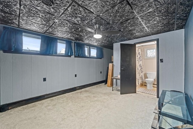 basement featuring carpet and ceiling fan