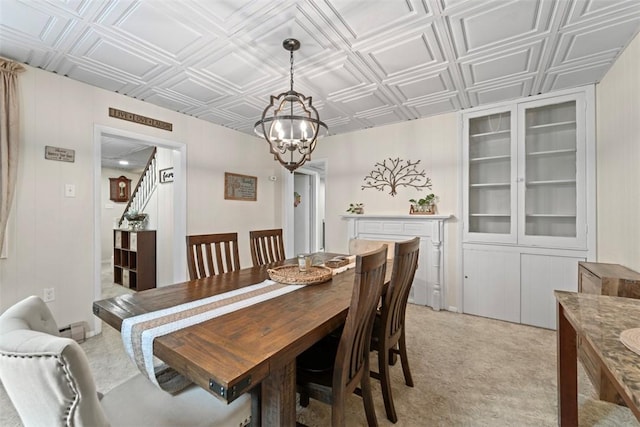 carpeted dining space featuring baseboard heating and a notable chandelier