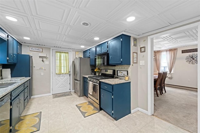 kitchen featuring a baseboard heating unit, blue cabinets, light stone countertops, light colored carpet, and stainless steel appliances