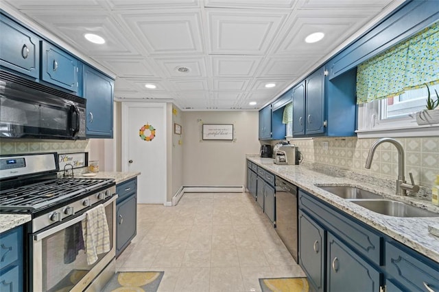 kitchen with decorative backsplash, appliances with stainless steel finishes, light stone countertops, blue cabinets, and sink